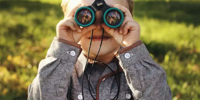 Enfant gros plan paire de jumelles Terres d'Oiseaux